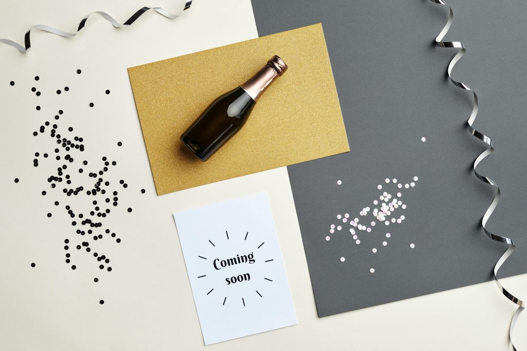 Flat lay image of a champagne bottle and festive decorations, perfect for celebratory themes.