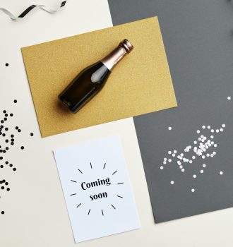 Flat lay image of a champagne bottle and festive decorations, perfect for celebratory themes.